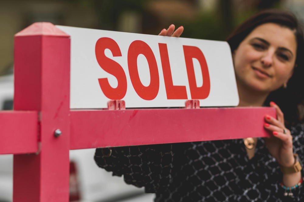 Realtor with SOLD sign